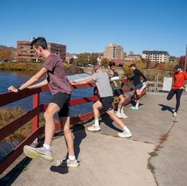 Group of runners warming up by a waterfront group of runners stretching by a waterfront