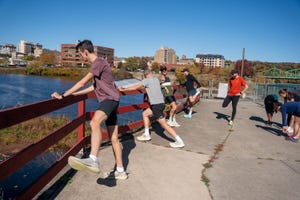 group of runners stretching by a waterfront