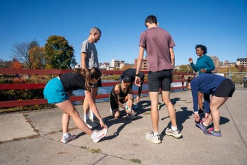 group of people stretching before a workout near a river