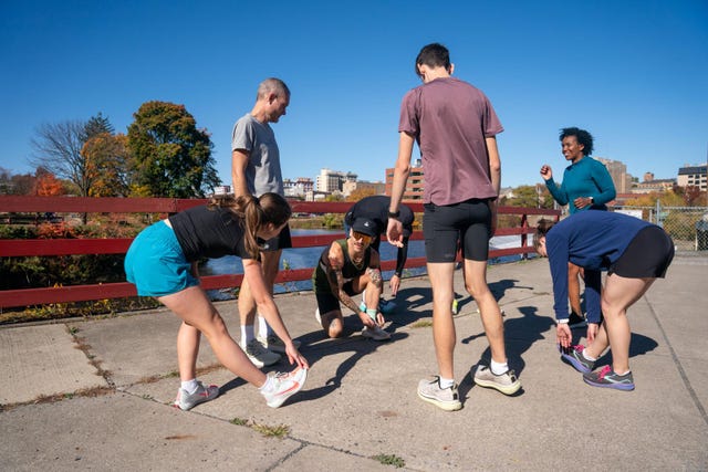 group of people stretching before a workout near a river