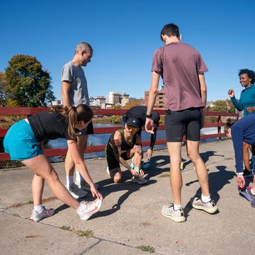 Group of people stretching before a workout near a river group of people stretching before a workout near a river