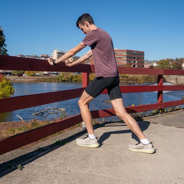 Person stretching by a river with a city skyline in the background person stretching by a river with a city skyline in the background