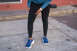 person in athletic wear stretching on the sidewalk