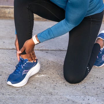 Person kneeling on pavement while holding their ankle person kneeling on pavement while holding their ankle