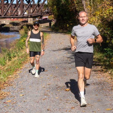 two individuals jogging along a gravel path by a waterway two individuals jogging along a gravel path by a waterway
