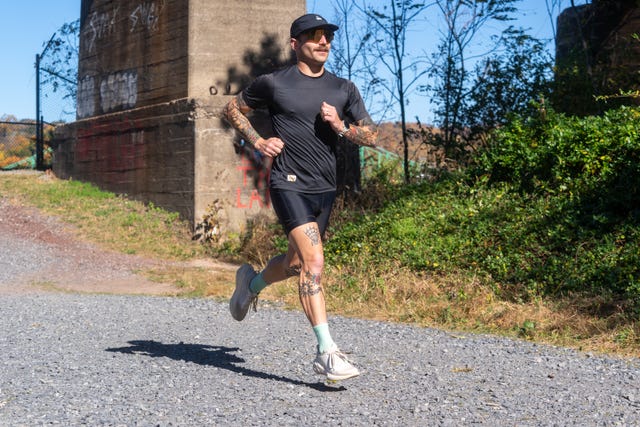 a person jogging on a gravel path in a natural setting