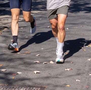 Three runners moving along a street with fallen leaves three runners moving along a street with fallen leaves