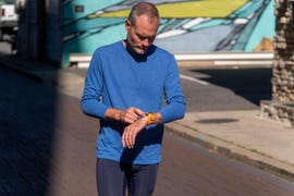 person checking a wristwatch while walking on a street