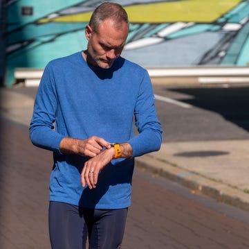 person checking a wristwatch while walking on a street person checking a wristwatch while walking on a street
