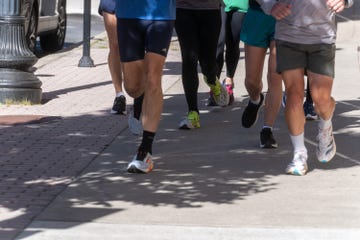 a group of people running down the sidewalk