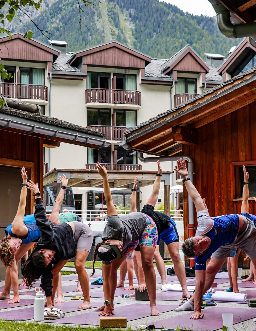 group of people doing yoga outside with mountains in the background