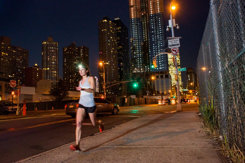 Runner at night with city in background