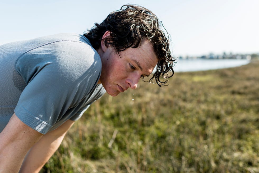 Runner Dripping Sweat and Knelt Over While Resting