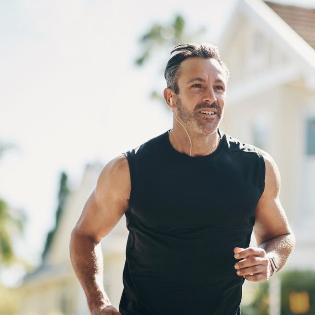 runner, fitness and senior man running, listening to music outdoor in neighborhood for workout wellness, energy and healthy lifestyle motivation. sports person with exercise training goal in street