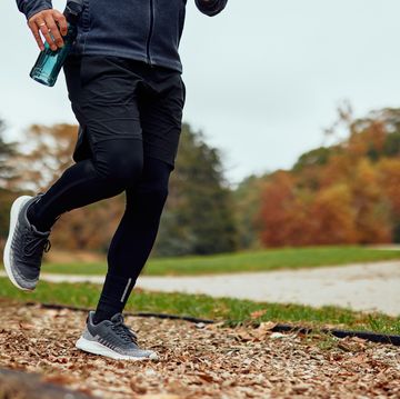 runner jogging on park trail in autumn afternoon