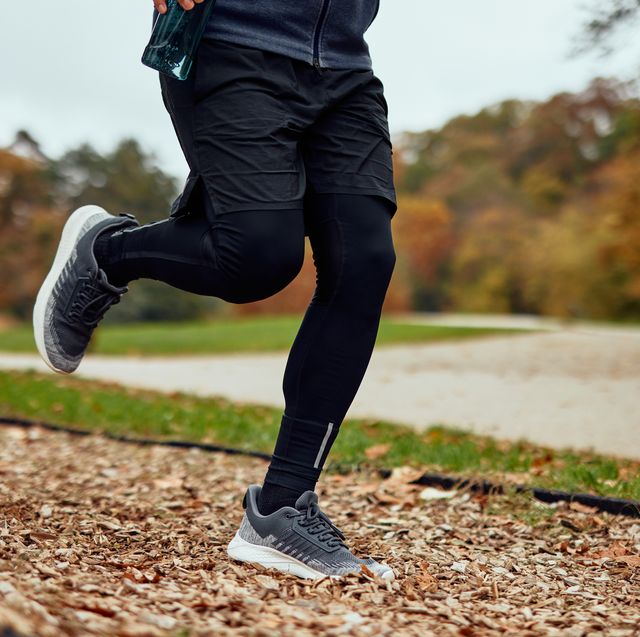 runner jogging on park trail in autumn afternoon