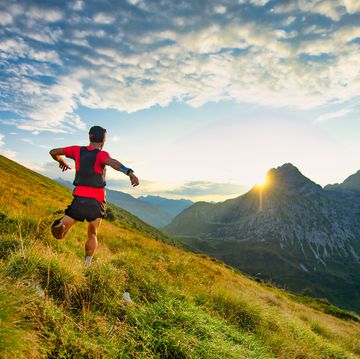 runner skyrunner on a mountain meadow at dawn