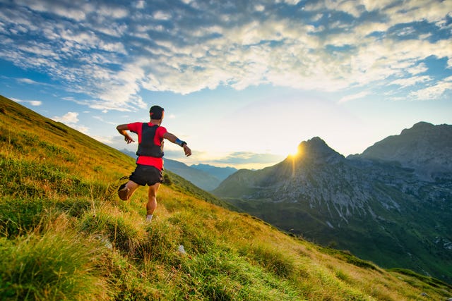 runner skyrunner on a mountain meadow at dawn