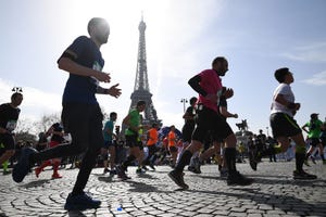 a group of runners run past the eifel tower