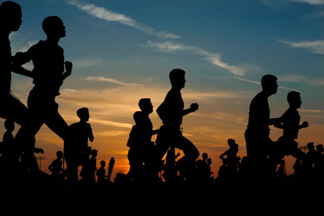 runners corriendo en una carrera al atardecer
