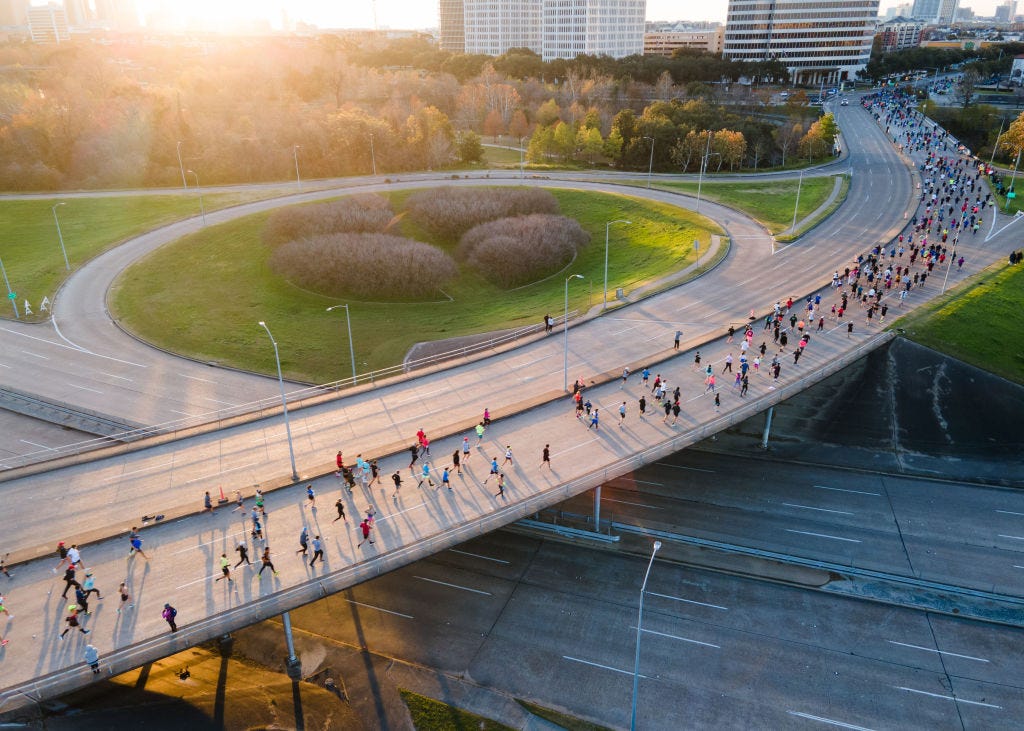 a large crowd of runners on a bridge