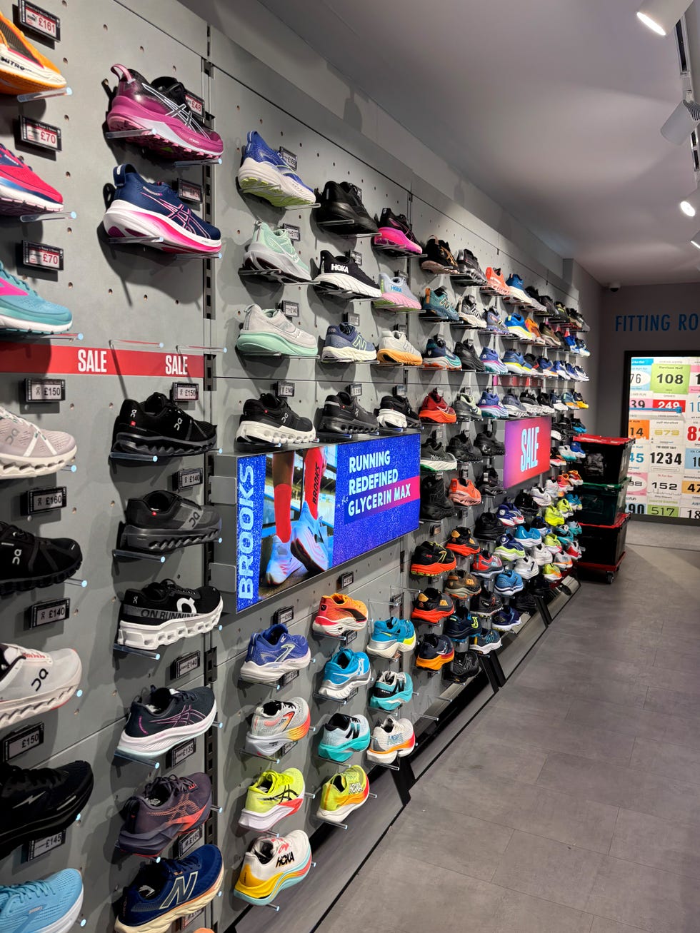 a wall of running shoes at a running store