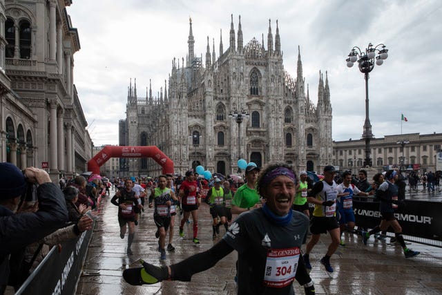 un hombre pasa corriendo por delante de la piazza del duomo en el maratón de milán 2021