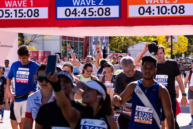 runners participating in a marathon event with timing displays for different waves