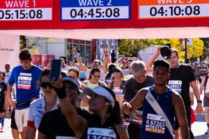 runners participating in a marathon event with timing displays for different waves