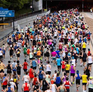 Large group of runners participating in a marathon on a city street Large group of runners participating in a marathon on a city street