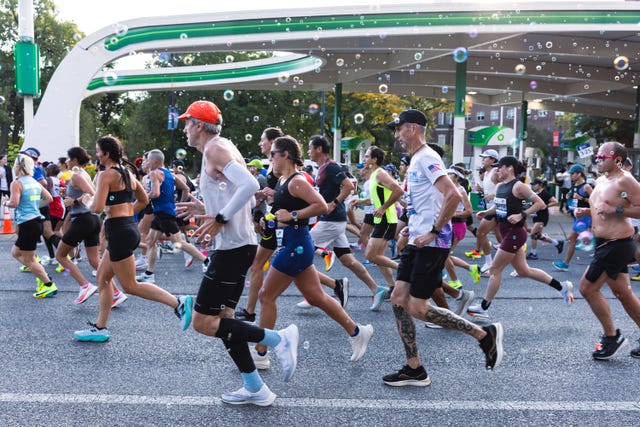 a pack of runners during a marathon with bubbles overhead
