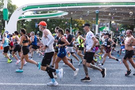 a pack of runners during a marathon with bubbles overhead