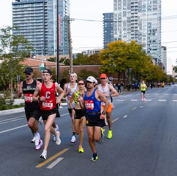 Runners participating in a marathon event on an urban street Runners participating in a marathon event on an urban street