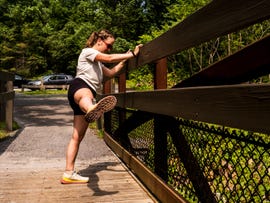 a runner stretching along a fence