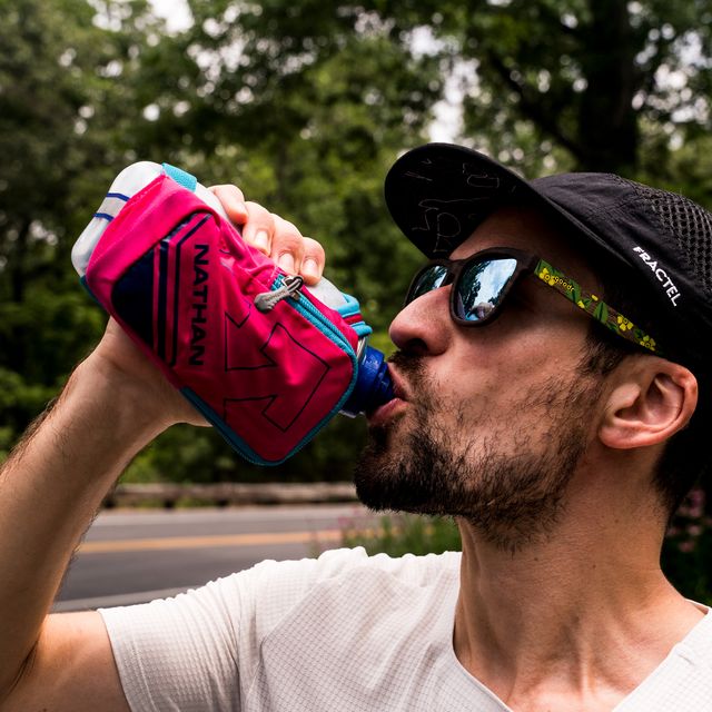 runner drinking water from a handheld water bottle