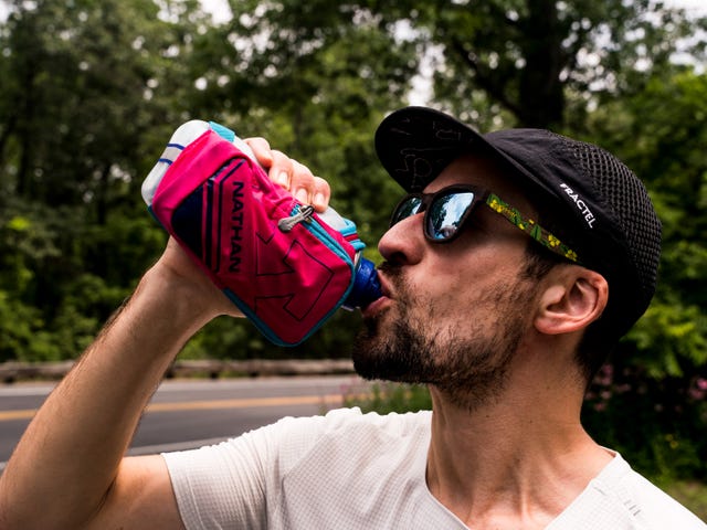 runner drinking water from a handheld water bottle