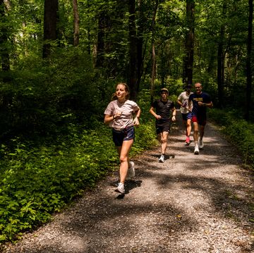 a group of people running 45ts201 on a trail in the woods