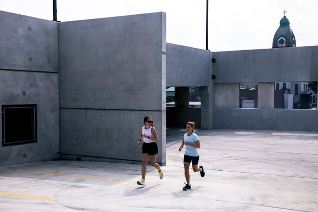 two women running in a parking garage