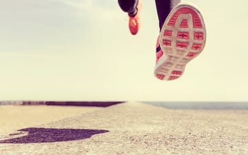 Young man running outdoors, mid air, low section