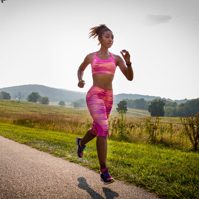 young female runner running in rural park