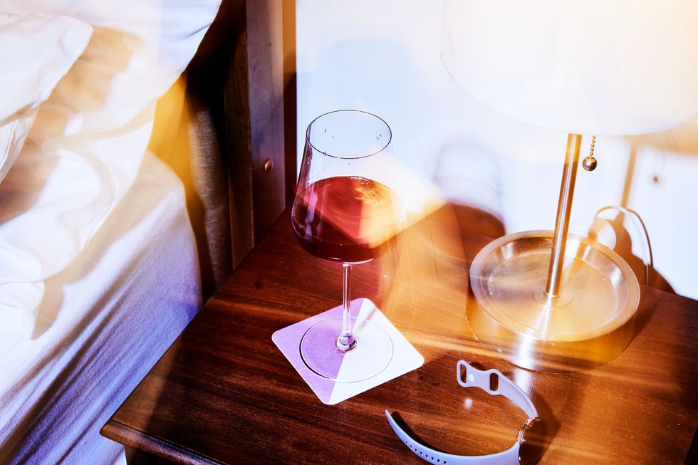 blurry wine and fitness tracker on bedside table
