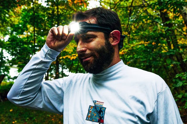 person outdoors signaling with their hand wearing a longsleeve shirt