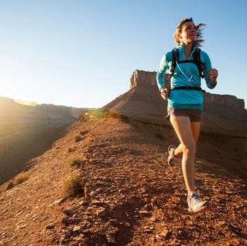 vrouw is aan het trailrunnen in de bergen