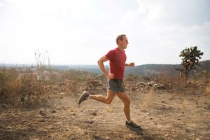 man loopt hard in duinen