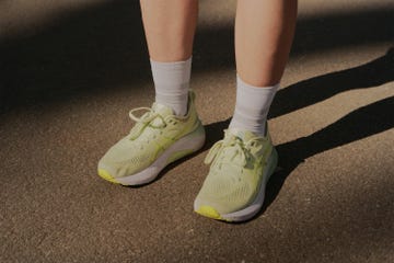 a pair of legs wearing green running shoes
