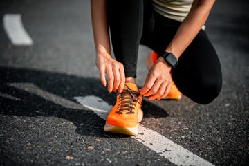 running shoes woman tying shoe laces closeup of female sport fitness runner getting ready for jogging outdoors on forest path in late summer or fall jogging girl exercise motivation heatlh and fitness