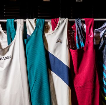 a group of Moon running singlets hanging on a rolling rack