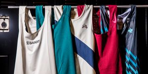 a group of running singlets hanging on a rolling rack