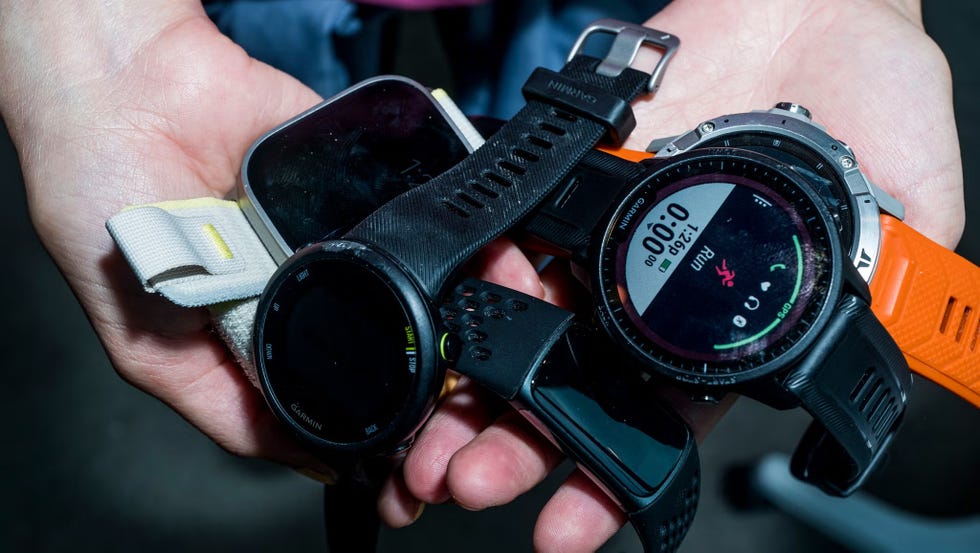 multiple smart watches held in a hand