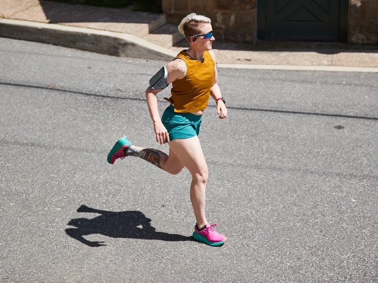 sue running down the street wearing earbuds